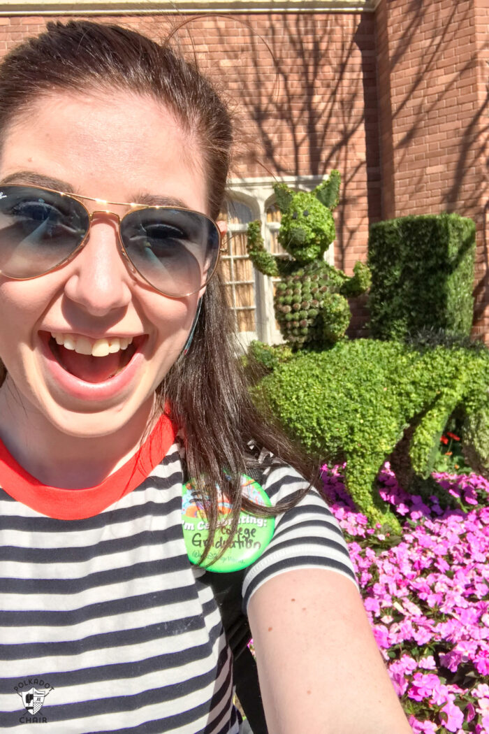 girl taking selfie in front of Epcot topiary