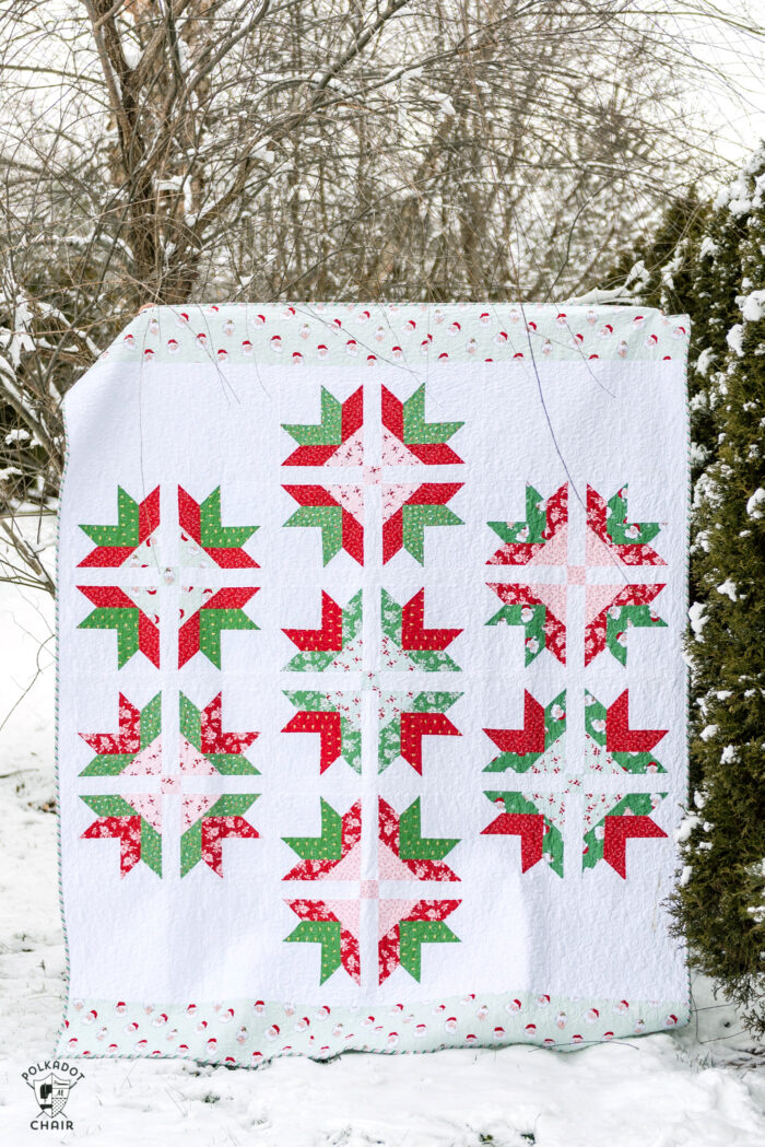 red, white and green quilt in snowy yard