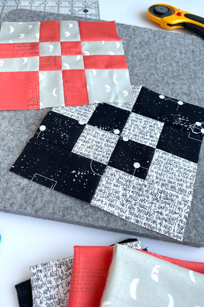 red, black and gray quilt blocks on gray cutting mat