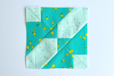 aqua, blue, & orange quilt blocks on white table