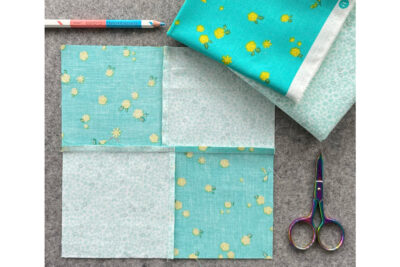 aqua and blue quilt block on gray pressing mat
