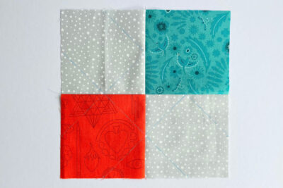 aqua, blue, & orange quilt blocks on white table