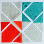 aqua, blue, & orange quilt blocks on white table