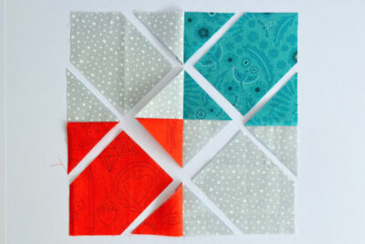 aqua, blue, & orange quilt blocks on white table