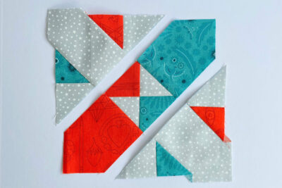 aqua, blue, & orange quilt blocks on white table