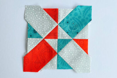 aqua, blue, & orange quilt blocks on white table