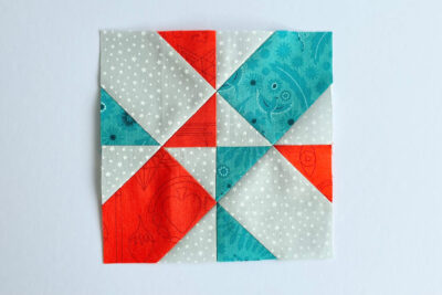 aqua, blue, & orange quilt blocks on white table