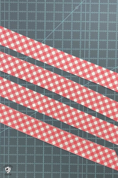 pink gingham fabric strips on blue cutting mat
