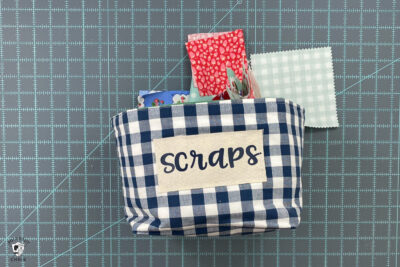 fabric basket with "scraps" label on cutting mat