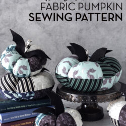 stack of fabric pumpkins on white table with gray background