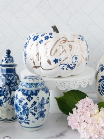 a collection of blue and white pumpkins on a white counter top with flowers