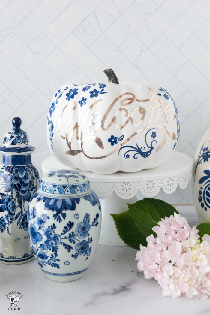 a collection of blue and white pumpkins on a white counter top with flowers