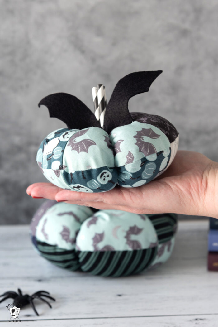 stack of fabric pumpkins on white table with gray background