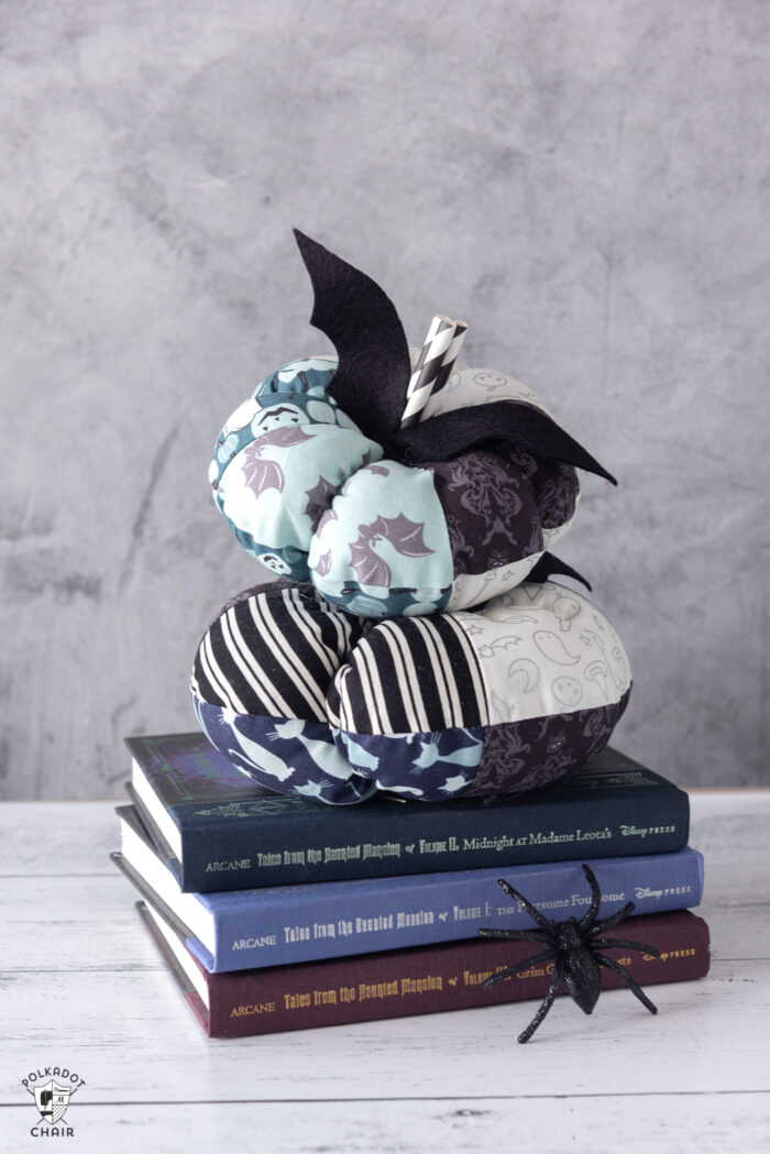 stack of fabric pumpkins on white table with gray background