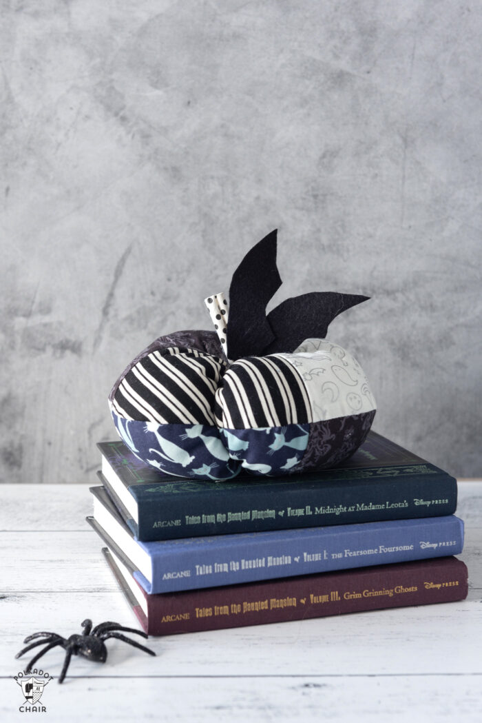 stack of fabric pumpkins on white table with gray background