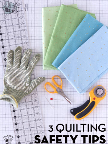 hand with cut glove on white cutting mat with quilt ruler and rotary cutter