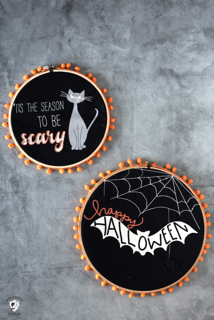 black fabric embroidery hoops on gray table with orange pom pom trim