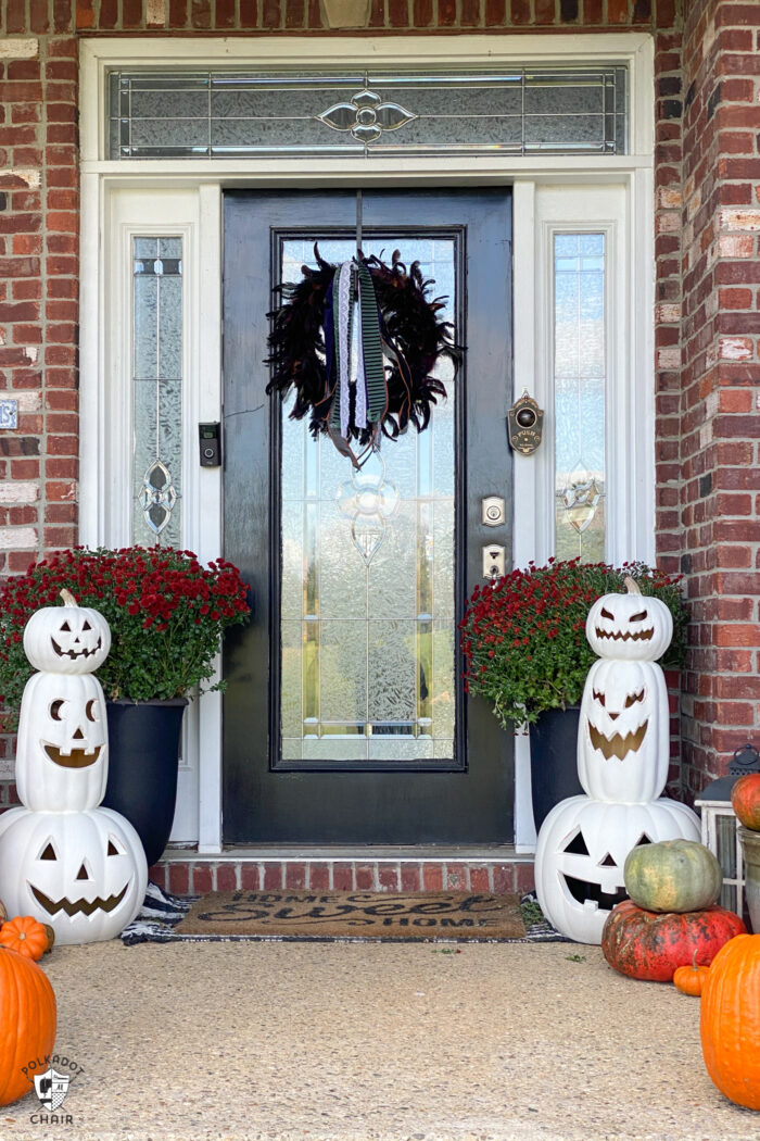 front porch decorated with plastic pumpkins and real pumpkins