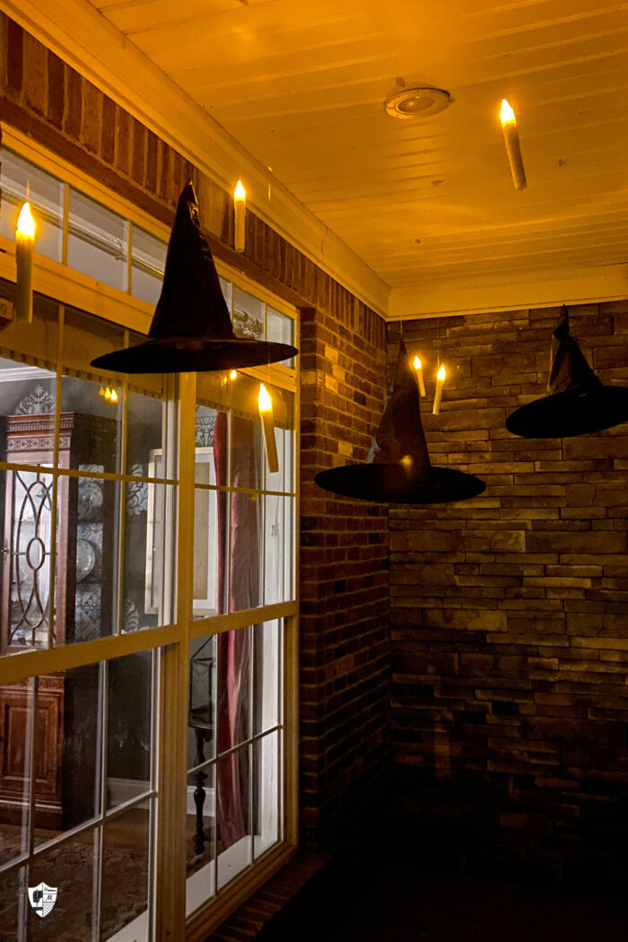 LED candles floating on front porch with black witch hats at night