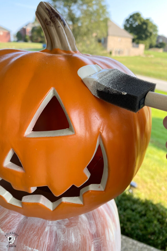 paint brush on pumpkin with white paint