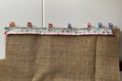 long strip of fabric folded in half and pinned to burlap