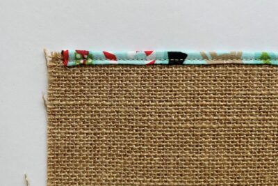 long strip of fabric folded in half and pinned to burlap