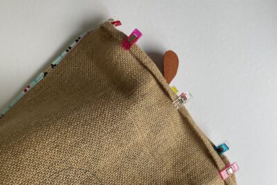 edge of burlap sack folded over and held in place with clips