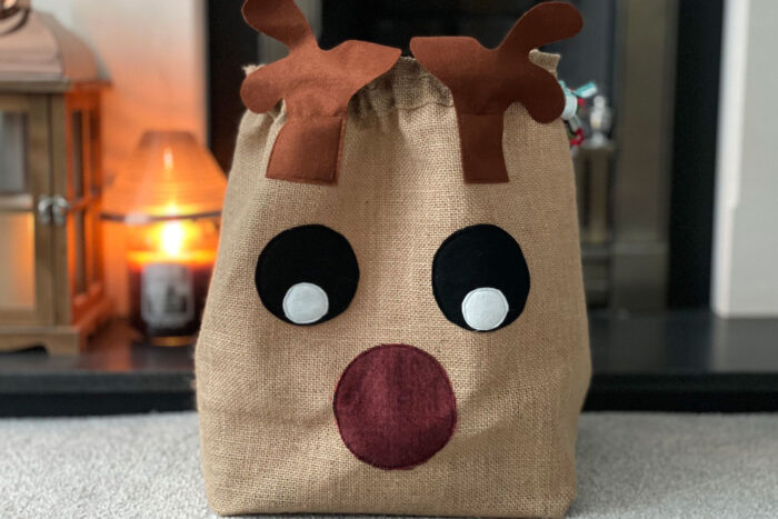 Burlap reindeer sack on table in front of candle