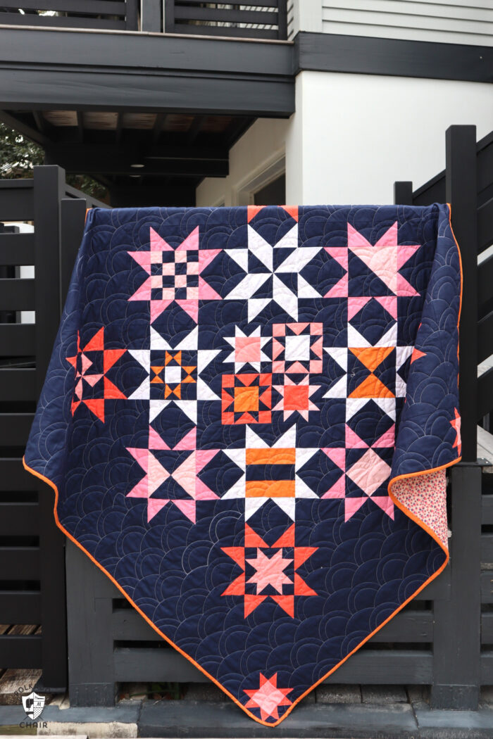 Navy, pink and orange modern star quilt on black staircase railing