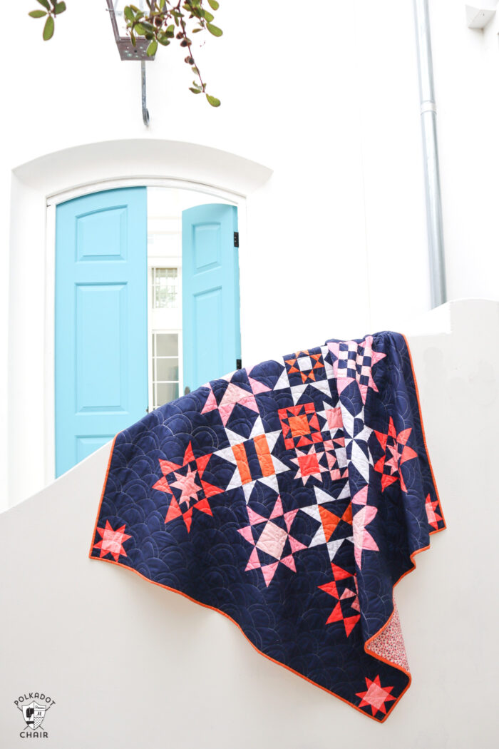 Navy, pink and orange modern star quilt on white fence