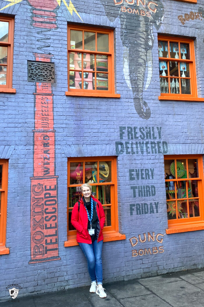 woman in red coat in front of blue wall