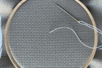 white stitching on tan embroidery fabric with needle