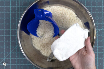 hand holding sock over bowl of rice