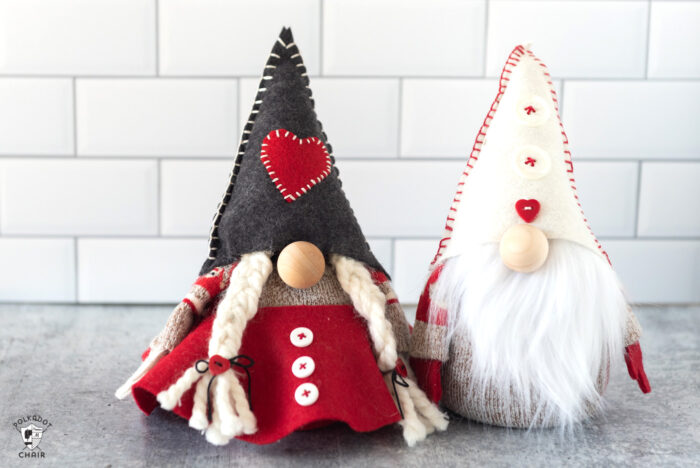 Red & gray stuffed Christmas gnomes on white countertop with books