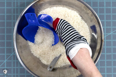 hand holding sock over bowl of rice