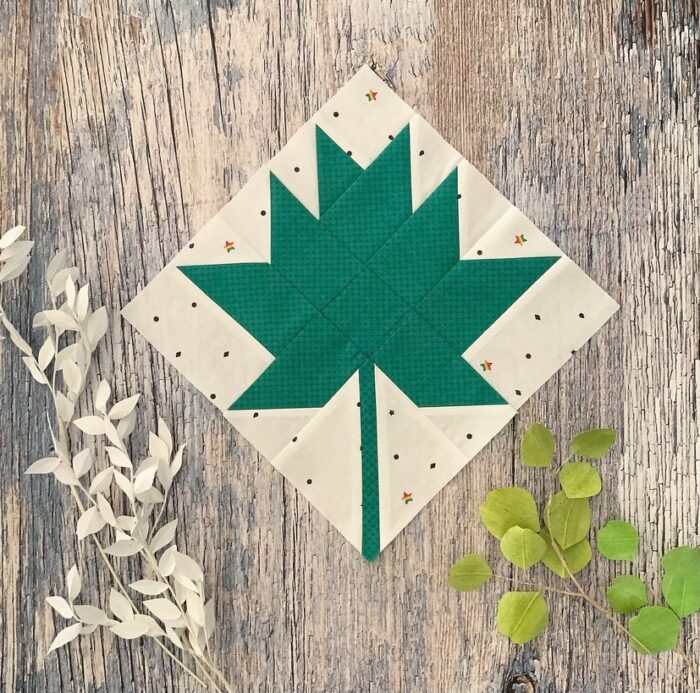 green leaf quilt block on wood table