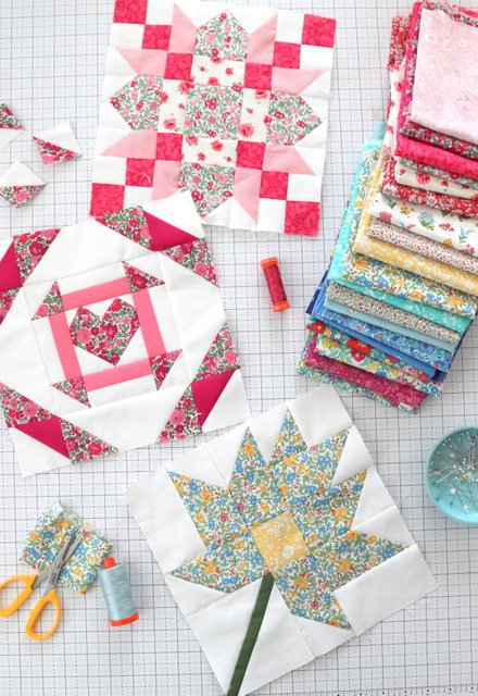 colorful quilt blocks and fabric stack on white cutting mat