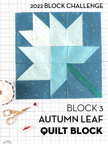 White blue and green quilt block on white cutting mat with folded fabrics