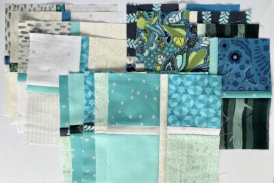 blue fabrics cut and pieced together on white table