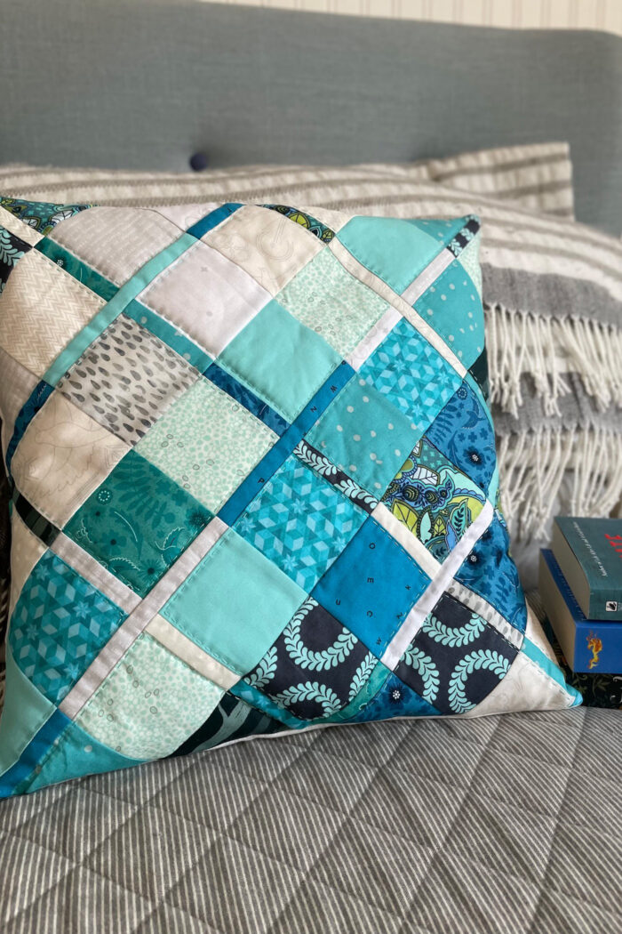 blue plaid quilted pillow on bed with books