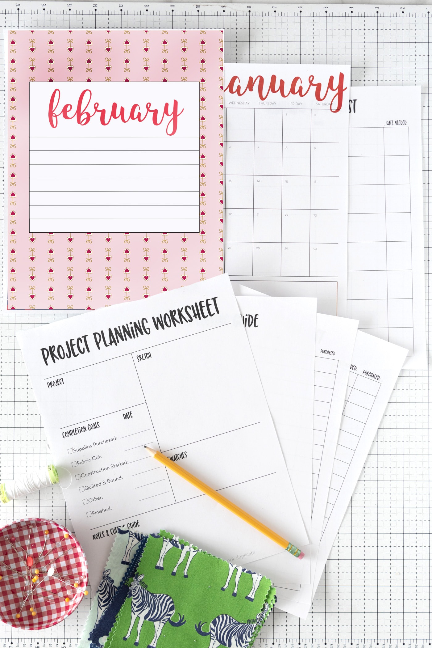 flat lay of printed planner pages and calendar with desk supplies on table