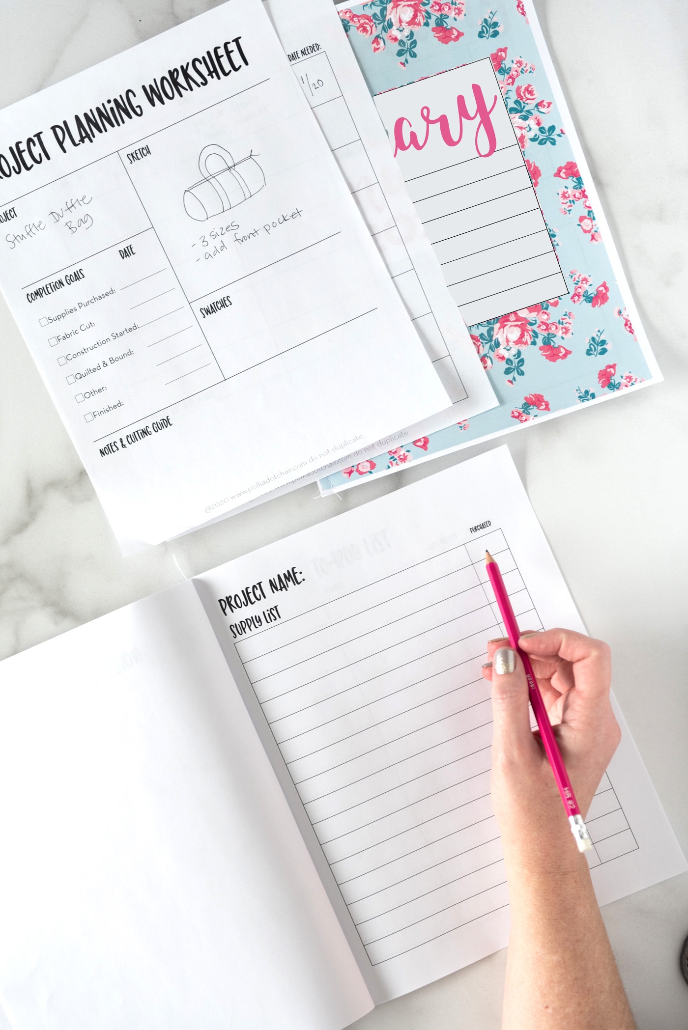 flat lay of printed planner pages and calendar with desk supplies on table