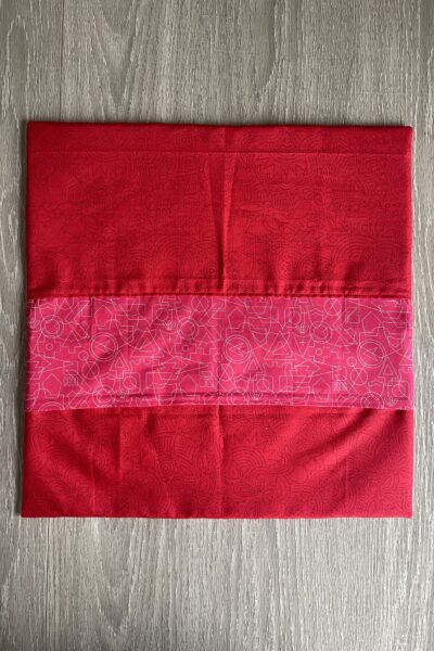 red fabric pillow sham on wood table