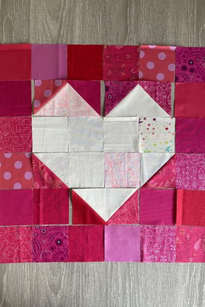 red fabric with white heart in center on wood table