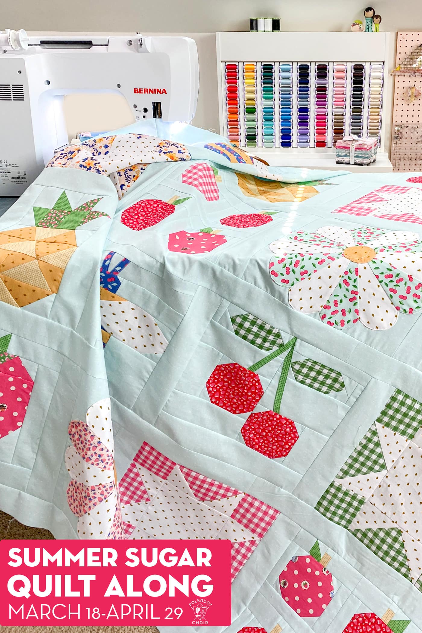 quilt top laying on sewing table under sewing machine with thread box in background