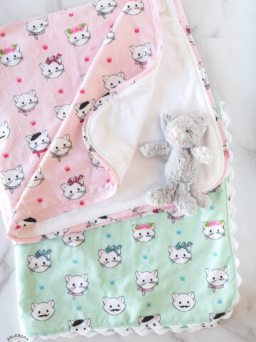 pink and mint flannel blankets on white table top with small toy cat