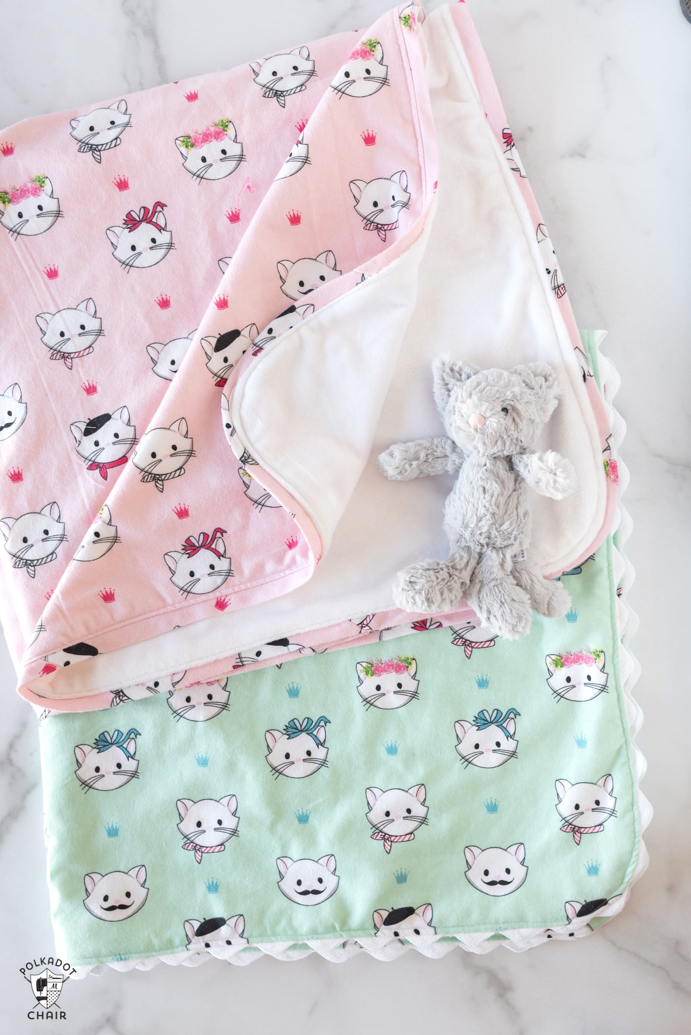 pink and mint flannel blankets on white table top with small toy cat