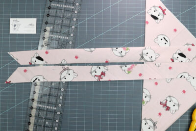 pink strips of fabric on blue cutting mat