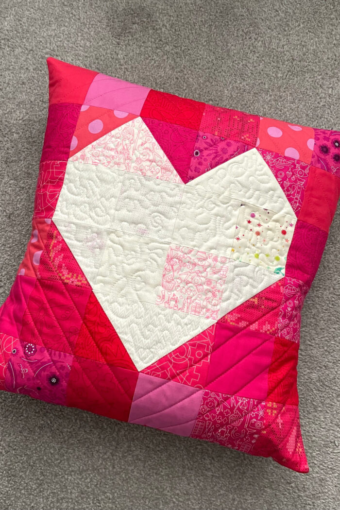 Quilted red pillow with white heart in the center