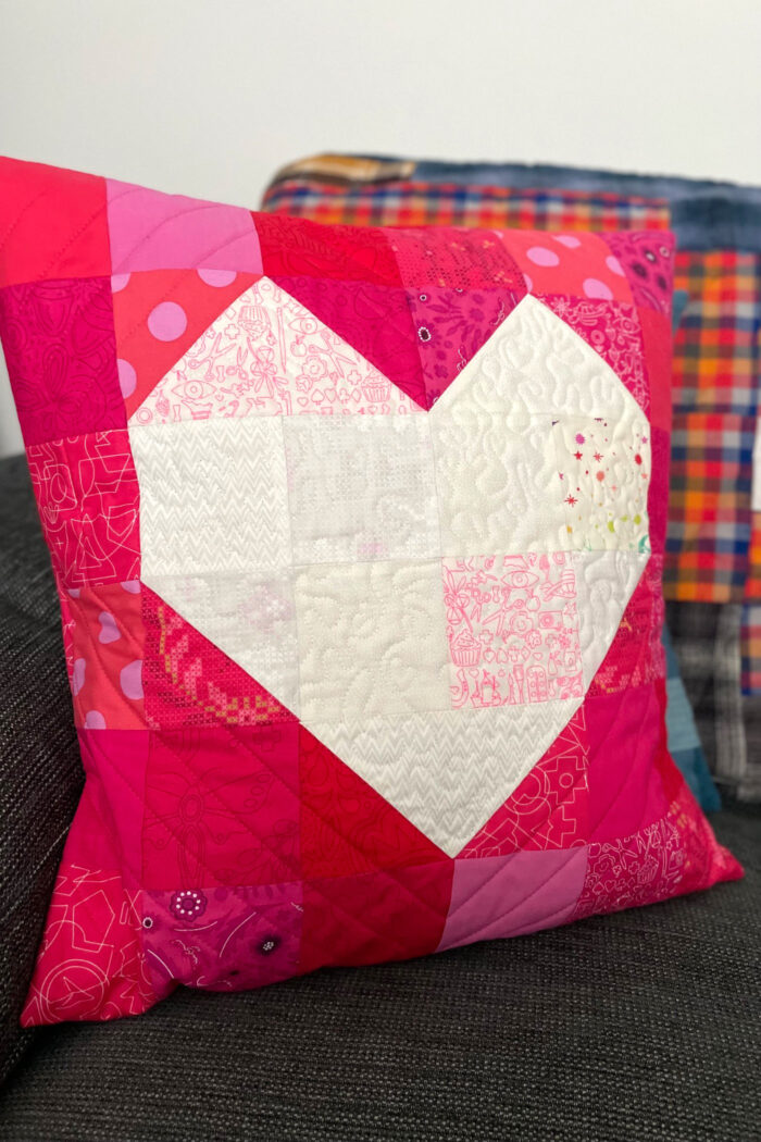 Quilted red pillow with white heart in the center